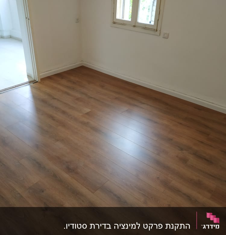 רצפת פרקט עץ בחדר ריק עם דלת פתוחה